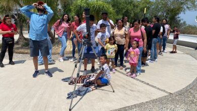 Familias acuden al planetario a observar el eclipse total de sol.
